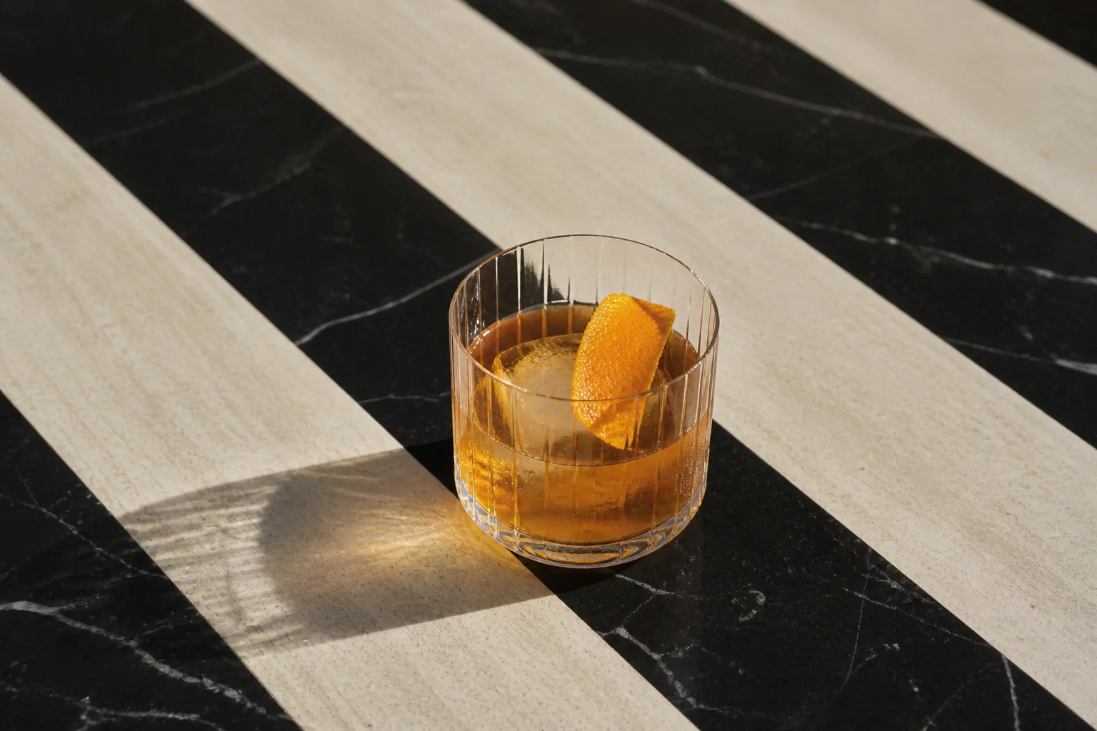 Old Fashioned at THE EMBER bar — clear ice, orange peel on striped marble