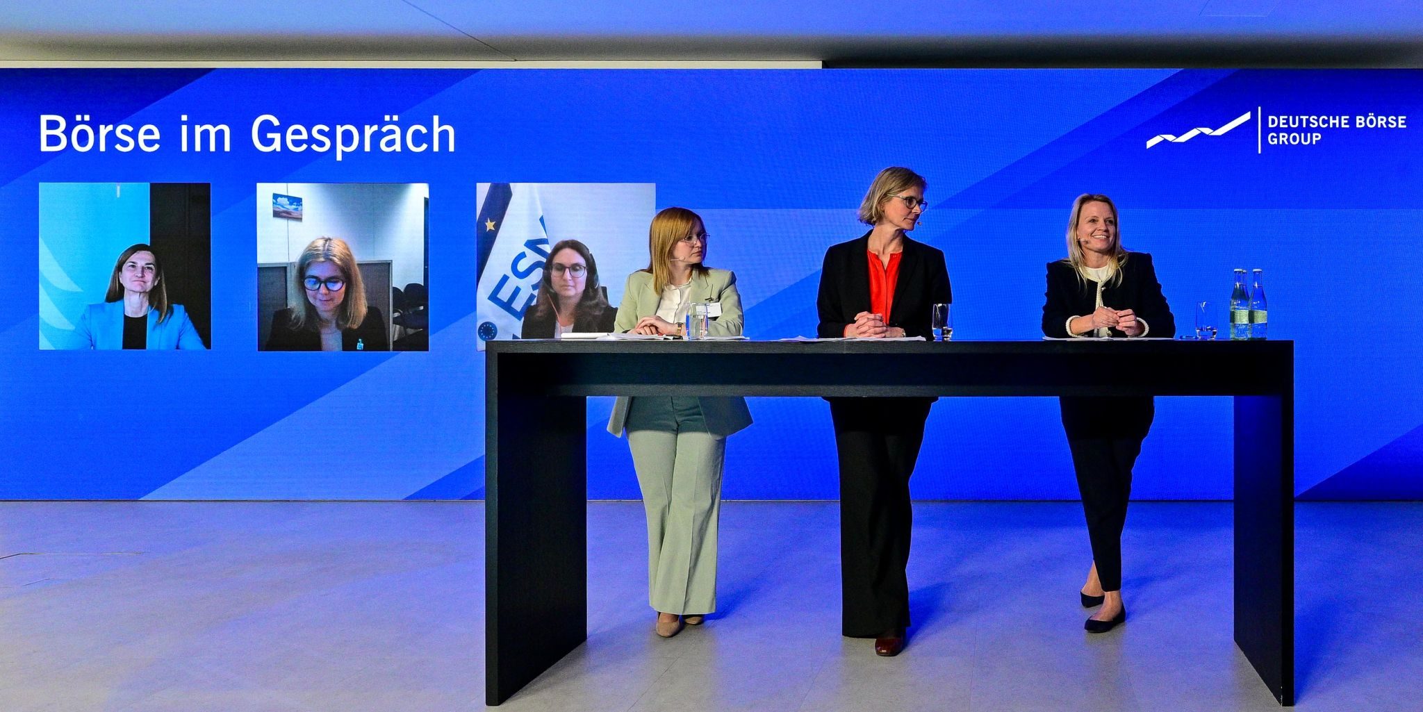 Moderator on stage with microphone in front of a conference audience